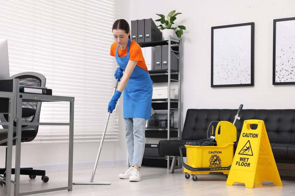 Cleaner mopping an office floor
